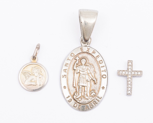 Lote com 3 pingentes em prata 925, 1 cruz com pedras, 1 medalha de anjo e 1 medalha de Santo Expedito / Peso total: 8,5gr