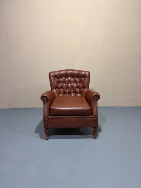 Lote 70 Poltrona estilo chipandele em captonê em couro sintético, braços tacheados, pés ... Valor at