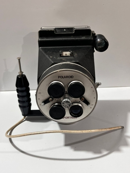 Polaroid Miniportrait, uma câmera analógica profissional desenvolvida pela Polaroid Corporation (EUA) e fabricada majoritariamente no Japão. Introduzida a partir de 1977, foi projetada especificamente