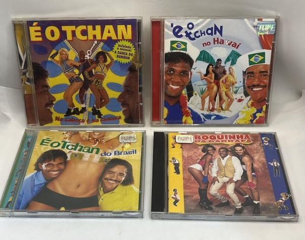 Lote com quatro CDs originais do grupo É o Tchan contendo os álbuns Na Cabeça e na Cintura, É o Tchan no Havaí, É o Tchan do Brasil e Boquinha da Garrafa. Coletânea de discos de música brasileira em b