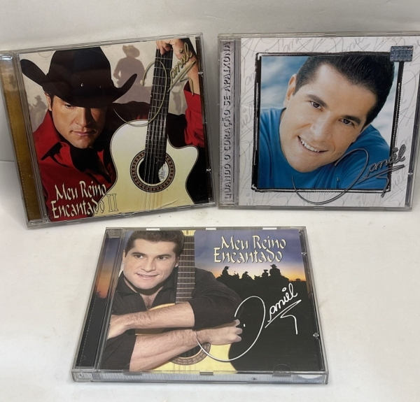 Lote com três CDs originais do cantor sertanejo Daniel composto pelos álbuns Meu Reino Encantado, Meu Reino Encantado II e Quando o Coração se Apaixona. Os discos trazem grandes sucessos da carreira d