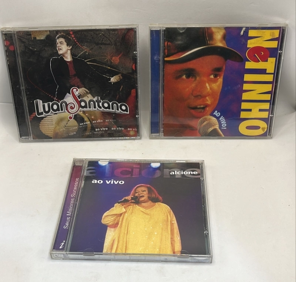Lote com três CDs originais de música brasileira reunindo os álbuns Ao Vivo de Luan Santana, Ao Vivo do cantor Netinho e Seus Maiores Sucessos de Alcione. Os discos apresentam uma seleção variada de h