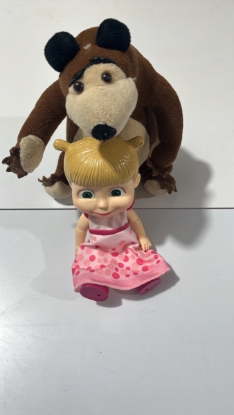 Conjunto de bonecos Masha e o Urso, composto por uma boneca em vinil com vestido rosa e um urso de pelúcia marrom. Os itens representam os personagens clássicos da animação infantil e encontram-se em