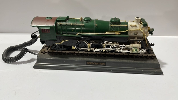 Raro telefone vintage estilo locomotiva `Crescent 1925`, produzido pela marca Telemania (KCL Technology Ltd). Esta peça decorativa e funcional apresenta um design detalhado de trem sobre trilhos com t