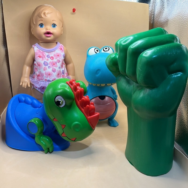 Lote de Brinquedos Infantis com Boneca Baby Alive em Vinil, Inclui Mão de Punho do Hulk em Plástico Verde e Figuras de Dinossauros Estilizados em Cores Vibrantes. Itens em Bom Estado de Conservação co