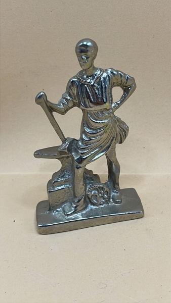 Estatueta de Ferreiro em Liga Metálica com Acabamento Prateado Brilhante, Peça Decorativa Detalhada com Base Retangular e Representação de Bigorna e Engrenagem. Escultura Colecionável de Estilo Indust