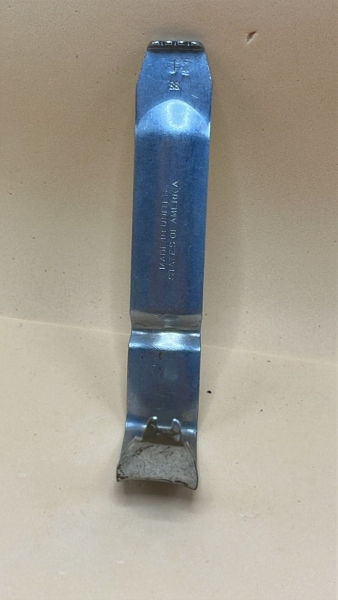 Presilha Militar de Fixação em Aço - USA Este item é uma peça de militaria autêntica, utilizada para prender acessórios (como porta-carregadores, cantis ou bainhas) ao cinto de combate. A marcação `SB