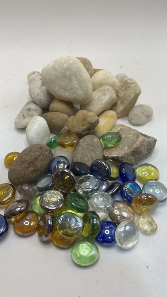 Lote de Pedras de Rio Naturais e Gemas de Vidro Decorativas.Conjunto misto contendo seixos de rio em tons de branco, bege e cinza, com texturas naturais e formatos arredondados, acompanhados por diver