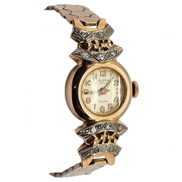 Relógio de pulso feminino "Super Atomic", estilo retro, mecânico de corda manual, com 17 rubis, de ouro amarelo 18k e aplicação de diamantes nos terminais. Peso total 27,4 gr. (Esse lote encontra-se e