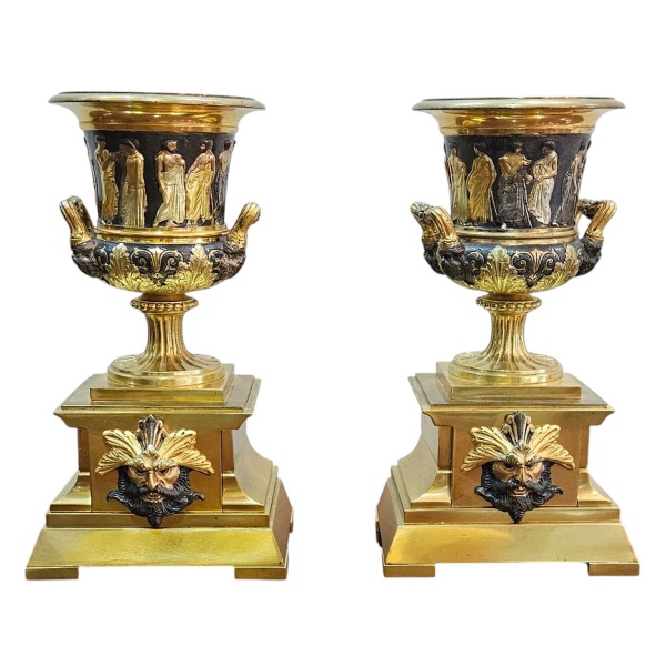 Importante par de ânforas de bronze dourado e patinado, base quadrangular escalonada decorada com cariátides representando Deus Toscano. Corpo em alto e baixo relevo com figuras greco romanas e estili