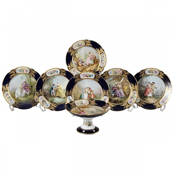Belo conjunto de fruteira e 6 pratos rasos, de porcelana de Sevrès Chateau des Luileries, séc. XIX, decorados a mão, assinados, plano com cenas românticas, bordas azul cobalto e a ouro, intercaladas p