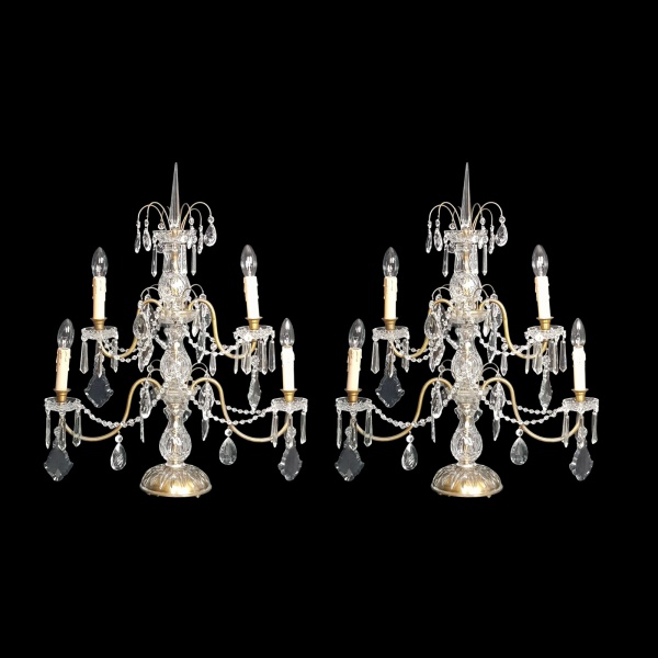 Par de grandes girandoles franceses do séc. XIX, para quatro luzes, de cristal lapidado com frisos geométricos. Braços curvilíneos de metal dourado, pingentes em correntes com placas de Versailles. 75