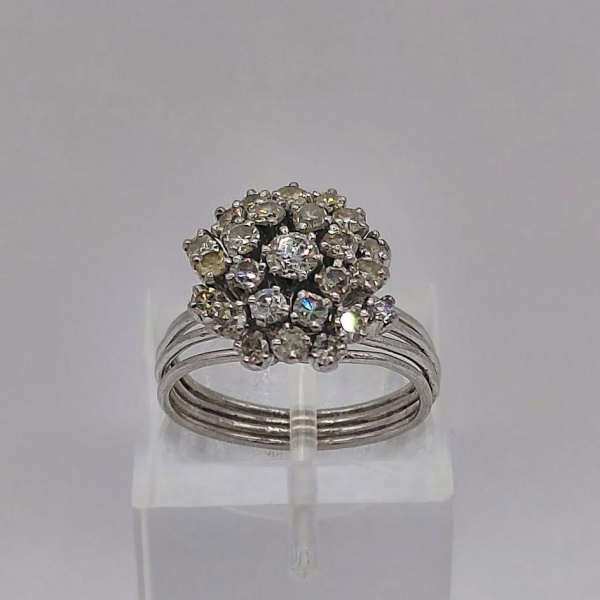 Anel chuveiro de ouro branco com diamante central de 10 pontos e 24 de 3 pontos cada. Peso de 5,2 gr. Aro 14,5.
