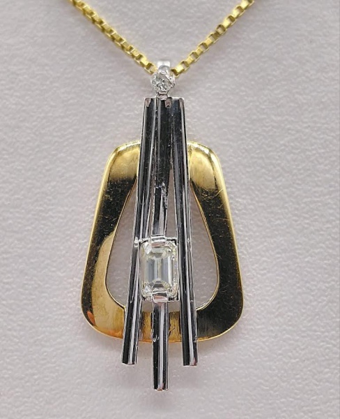 Pingente de ouro 18k anarelo e branco com diamante formato baguete de 25 pontos e 1 diamante de 3 pontos. Peso de 3,5 gr. Comprimento de 3.3 cm