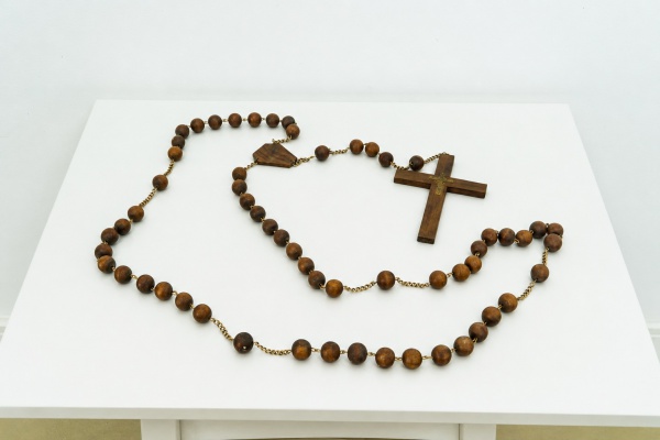 BRASIL - Antigo objeto decorativo de temática sacra, composto por contas esféricas, medalhão poligonal e crucifixo, em jacarandá maciço, interligados por uma corrente metálica. Crucifixo com represent