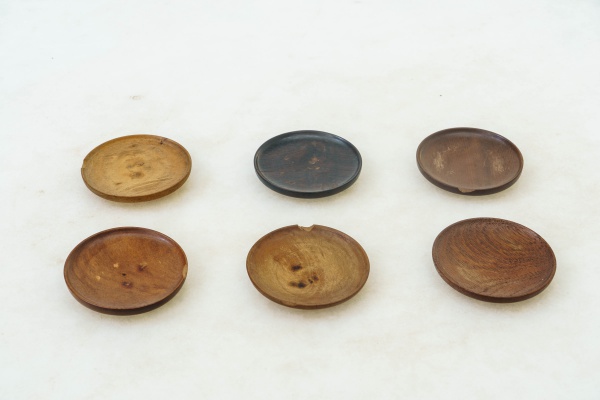 BRASIL - Conjunto com 6 belos porta-copos redondos em madeira nobre com variações naturais em suas tonalidades. Déc. 1960. Apresentam desgastes condizentes com o tempo. Dimensões: A 1,5 cm x D 9 cm. P