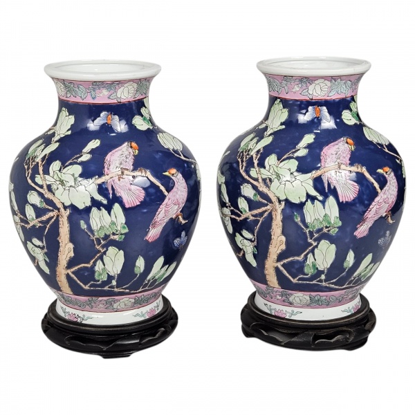 Par de vasos de porcelana chinesa de exportação, fundo azul cotalto decorado em policromia com pássaros encarapitados em ramos floridos. Formato bojudo com base e borda esmaltada em lilás ornamentados