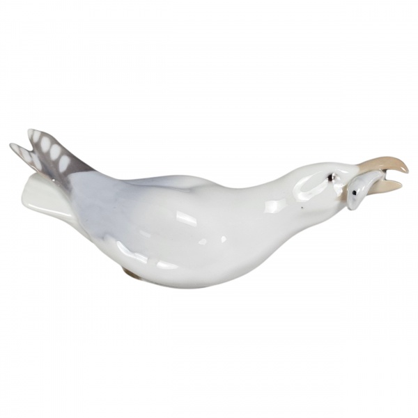 Elegante estatueta em porcelana fina dinamarquesa da renomada manufatura Bing & Grndahl (B&G), de Copenhague. Modelo oficial nº 1808, intitulado Seagull with Fish (Gaivota com peixe no bico), desenhad