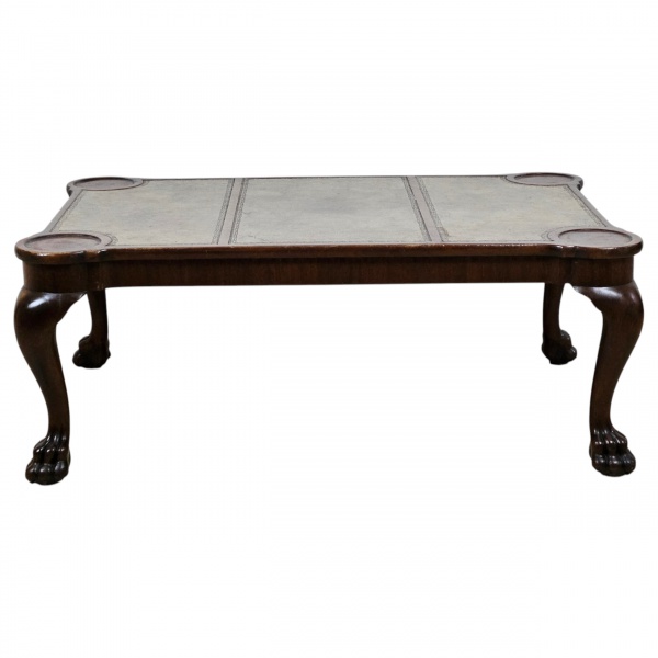 Mesa de centro, de madeira de lei, caixa retangular com tampo tripartido, revestido de couro. As quinas detalhes com círculos, provavelmente para porta copos. Pernas de joelheiras pronunciadfas e pés