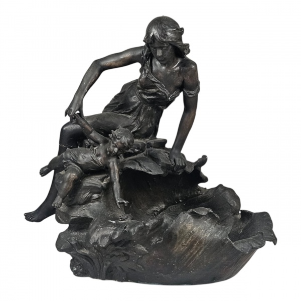Floreira escultórica em petit bronze, fundido e patinado representando cena bucólica de maternidade, com floreiro decorado por motivos naturalistas. Observação: apresenta perna quebrada, passível de r