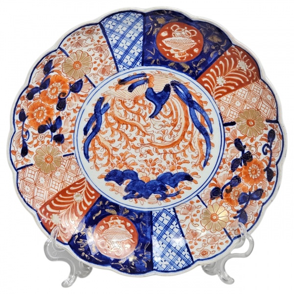 Prato circular de porcelana Imari, Japão, séc. XIX, período Meiji, de porcelana esmaltada e dourada com influência dos modelos Ming. Borda recortada, decoração e ornamentação com uso abundante de dour