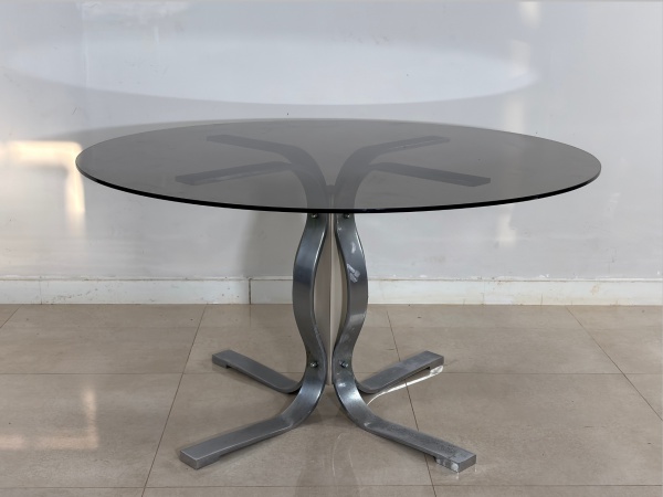 Mesa de Jantar, Anos 70 - Produzida em metal cromado com tampo em vidro, combinação de materiais que traduz a sofisticação e a linguagem moderna características do período. Seu desenho de linhas limpa