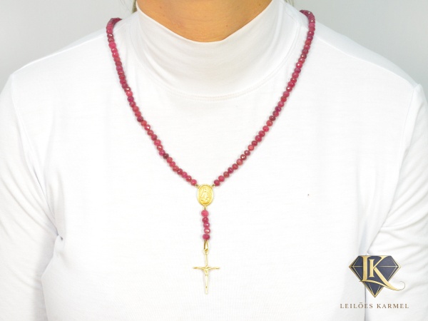 Terço de Rubis com Cruz e Medalha de Nossa Senhora do Rosário em Ouro Amarelo 18K, Comprimento: 70cm, Extensão central: 8.5cm, peso de 58.1 gramas. Acompanha Certificado de Garantia Leilões Karmel.