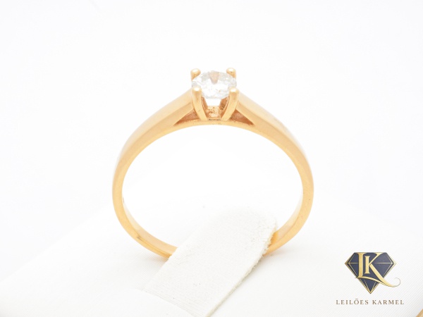 Anel Solitário em Ouro Amarelo 18K com Diamante de 20 Pontos, Lapidação: Brilhante, Cor: JK e Pureza: SI2, Aro 18, peso de 2 gramas. Acompanha Certificado de Garantia Leilões Karmel.