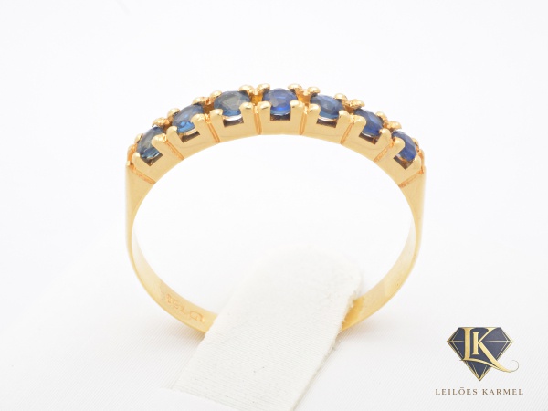 Meia Aliança em Ouro Amarelo 18K com Safiras Azul, Aro 18, peso de 1.5 gramas. Acompanha Certificado de Garantia Leilões Karmel.