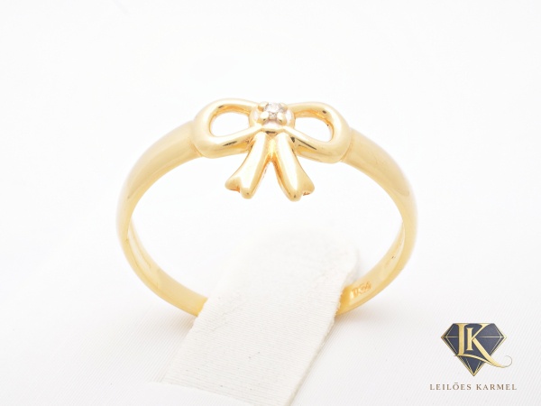 Anel Design Laço em Ouro Amarelo 18K com Diamante, Aro 13, peso de 1.1 gramas. Acompanha Certificado de Garantia Leilões Karmel.