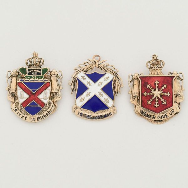 Conjunto contendo tres broches/pendentes em metais dourados e esmaltados a saber: 1- Insígnia Militar, historicamente ligada ao 103 rd Infantry Regiment do exército dos Estados Unidos. Na base do bras