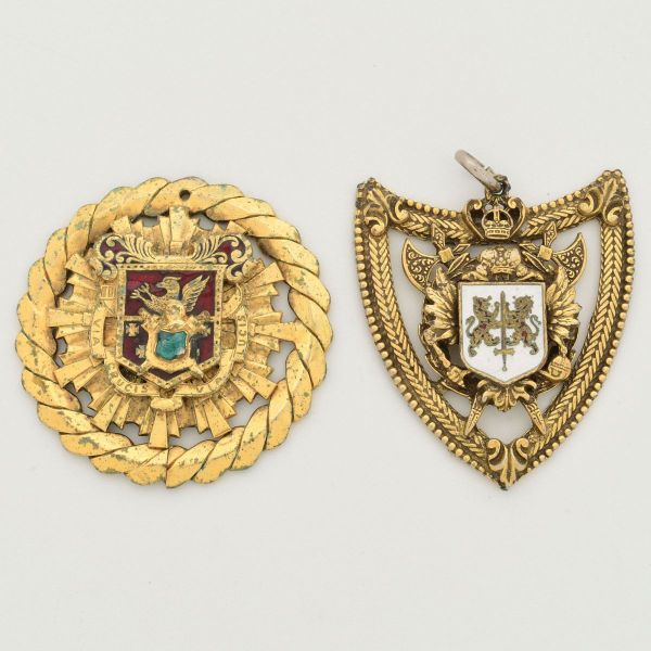 Duas comendas pendentes, em metal dourado, sendo: 1- Pingente católico vintage, com inscrições "Via Crucis - Caminho da Cruz e Via Lucis -Caminho da Luz". Apresenta um brasão heráldico estilizado com