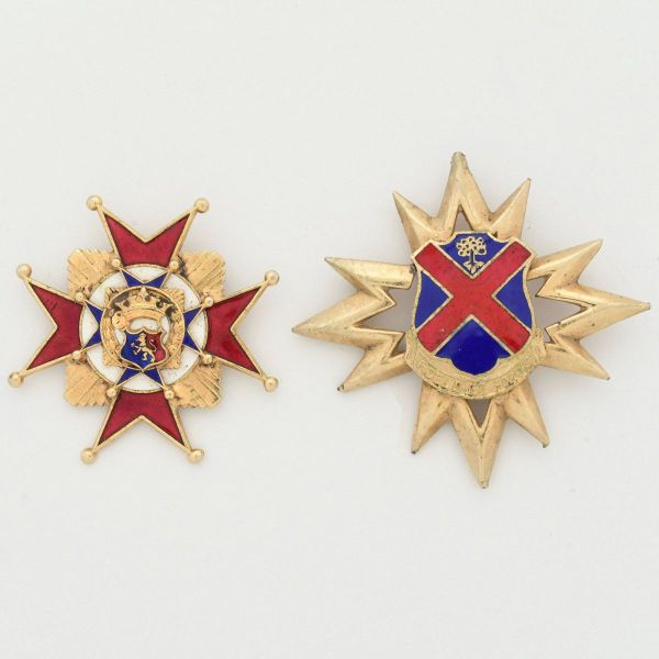 Dois broches em metal dourado, representando duas comendas, a saber: 1- Ordem dos Cavaleiros da Concórdia - uma condecoração de origem espanhola, apresentando uma estrela de braços esmaltados em verme