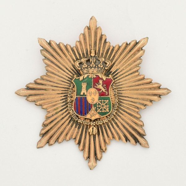 Placa da Ordem Civil de África - Broche insígnia de peito, em formato de estrela radiante dourada, apresentando no centro o escudo heráldico coroado, simbolizando os territórios sob administração e in