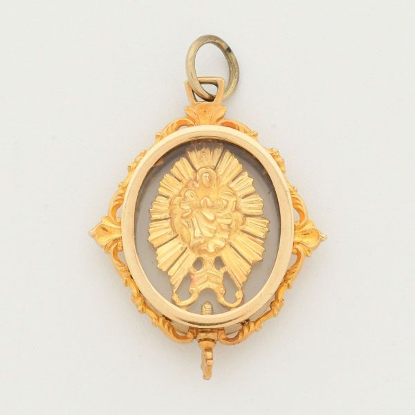 Pendente relicário colonial brasileiro em formato de custódia, em ouro amarelo 18 k e elo para colocação da corrente em prata dourada, protegida por tampas de vidro ou cristal. Apresenta um ostensório