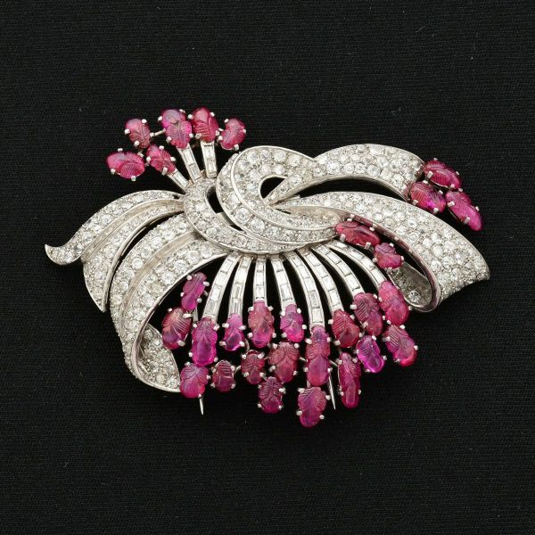 Esplêndido broche em platina, de alta joalheria, em formato de laço, confeccionado com aprox 203 diamantesde aprox 0,10 ct cada, aprox. 37 diamantes baguetes com aprox 0,12 ct cada e aprox. 33 rubis f