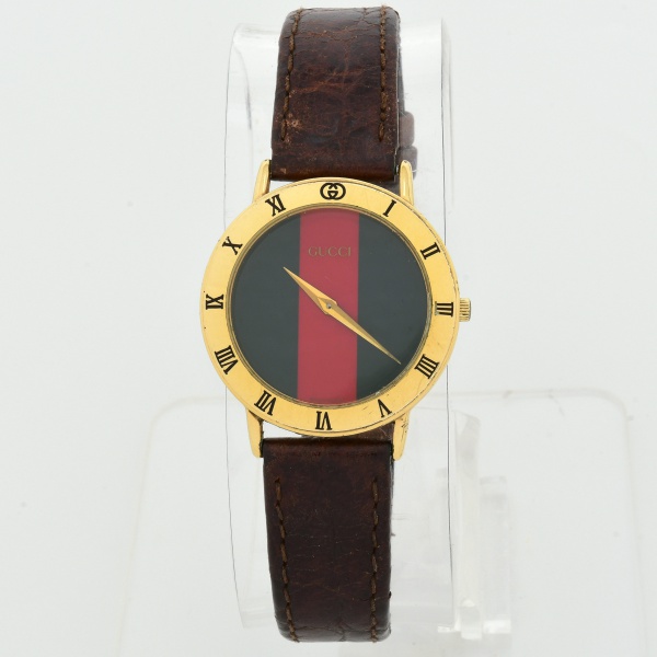 GUCCI 3000.2.M - Relógio masculino, vintage, caixa dourada, medindo 35 mm de diâmetro incluindo a corora. Mostrador Sherry Line, com tradicionais faixas verticais verde e vermelha da grife. Numerais e
