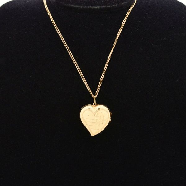 Colar de corrente e pingente de coração abaulado, estilo "puffy heart", em ouro amarelo 18 k, frequentemente funcionando como um relicário (locket), corrente de eelos interligados em estilo cadeado ou