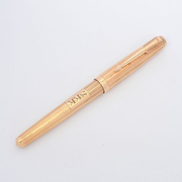 PARKER 61 - Caneta tinteiro vintage, com corpo e tampa em ouro amarelo 18 k e acabamento finamente cinzelado, design "Carioquinha". Apresenta textura cinzelada em padrão de linhas entrecortadas ao lon