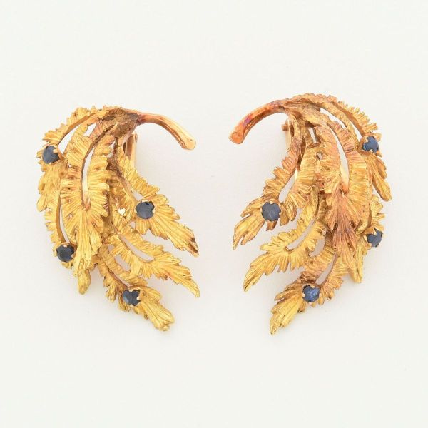 Par de brincos em ouro amarelo 18 k, modelo vintage com fecho de pressão, design em folhas de acanto, decoradas com pequenas pedras azuis, provavelmente safiras,com acabamento texturizado e cinzelado,