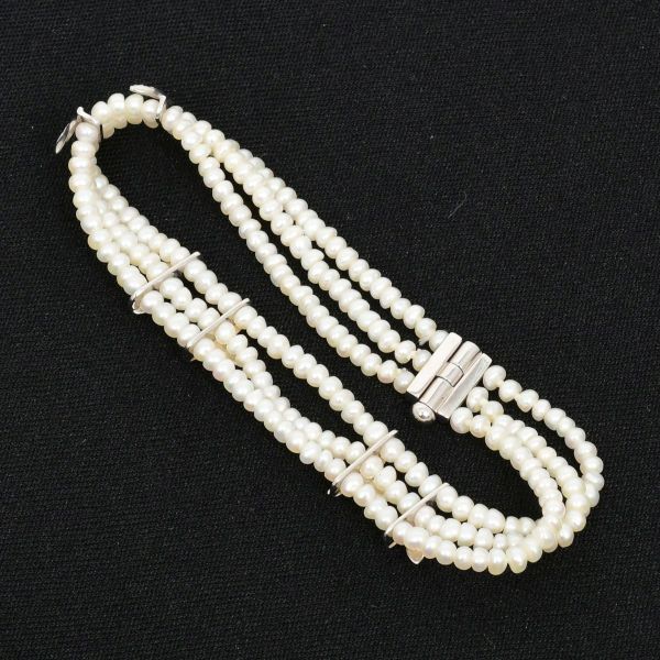H STERN - Pulseira em ouro branco 18 k, com tres fileiras de pequenas pérolas cultivadas, unidas verticalmente por passadores decorativos em formato de ramos, cravejados com mini diamantes e fecho de