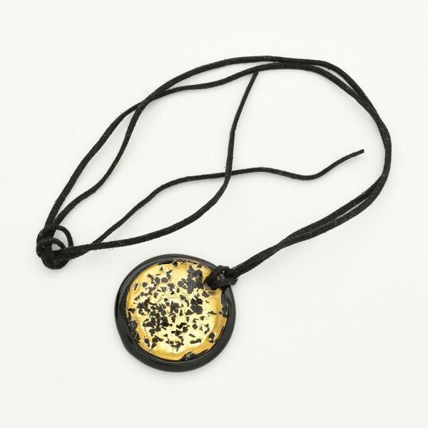Colar em murano italiano, caracterizado por um design circular com fundo preto brilhante e inclusões decorativas de folhas ou flocos sob uma camada dourada. Acompanha fio na cor preta medindo aprox 10