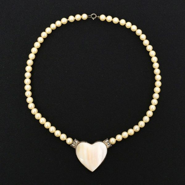 Colar com pérolas sintéticas de aproximadamente 7,0 mm, medindo 45,0 cm de comprimento no total, com pendente em formato de coração em madrepérola, com moldura em prata, medindo 4,5 x 3,0 cm. Peso tot
