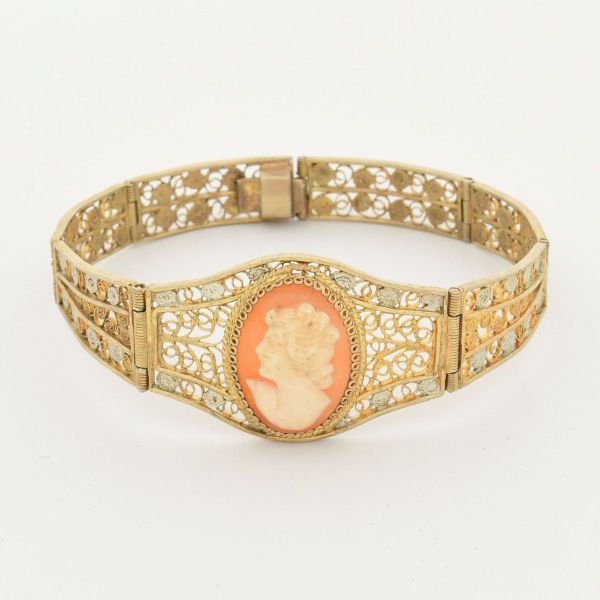 Pulseira vintage, em prata dourada articulada, apresentando painéis vazados e filigranados, tendo em sua parte principal, um camafeu oval, com perfil de uma mulher medindo 17,0 x 0,8 cm. Peso total 13