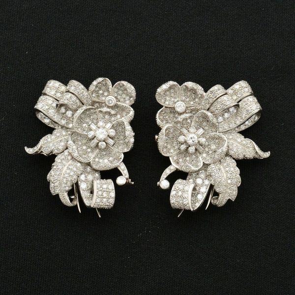 Elegantérrimo par de broches em platina, design floral, com face frontal detalhada com flor e suas pétalas tridimensionais, ambos cravejados com pavês de diamantes. Medida 4,1 x 3,1 cm. Peso total 41,
