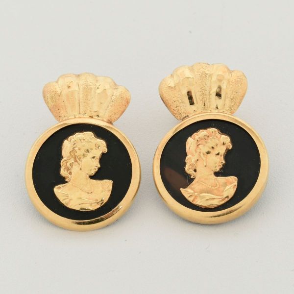 Par de brincos em ouro amarelo 18 k, modelo camafeu, com figura feminina ao centro, sobre baquelite na cor preta. Tarrachas sendo uma em prata 925 e outra em dourado. 2,4 x 1,5 cm. Peso total 4,0 g.