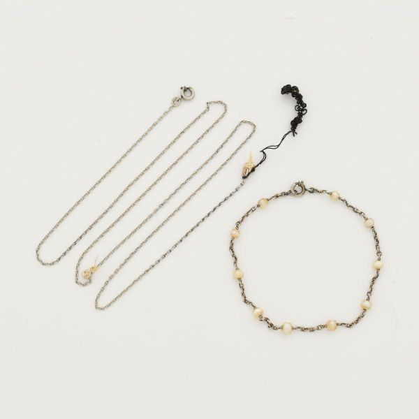 Corrente e pulseira em platina, sendo a corrente com aprox 47,0 cm de comprimento e a pulseira, decorada com pequenas pérolas, medindo 15,0 cm de comprimento. Peso total 4.6 g.