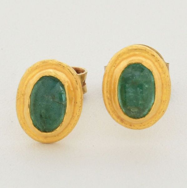 Par de brincos em ouro amarelo 18 k, decorado com duas esmeraldas ovais, sendo uma das tarrachas em prata dourada 925, contrastada. Comprimento 7mm. Peso total 1,6 g.