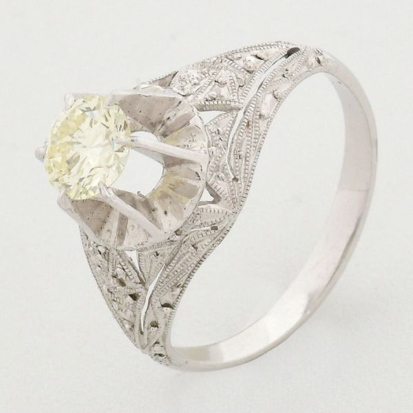 Anel em platina, estilo art decó, com diamante solitário de aproximadamente 0,75 ct tendo em suas laterais trabalho filigranado rendado. Aro 13/14. Peso total 3,2 g.