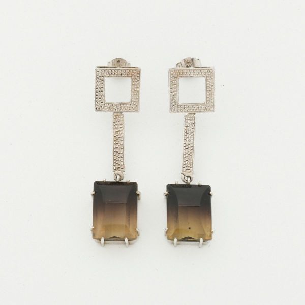 Par de brincos pendentes em ouro branco 18 k, com base quadrada, hastes articuladas e duas pedras de quartzo fumê (16 x 12 mm). Comprimento 5,0 cm. Peso total 14,8 g.